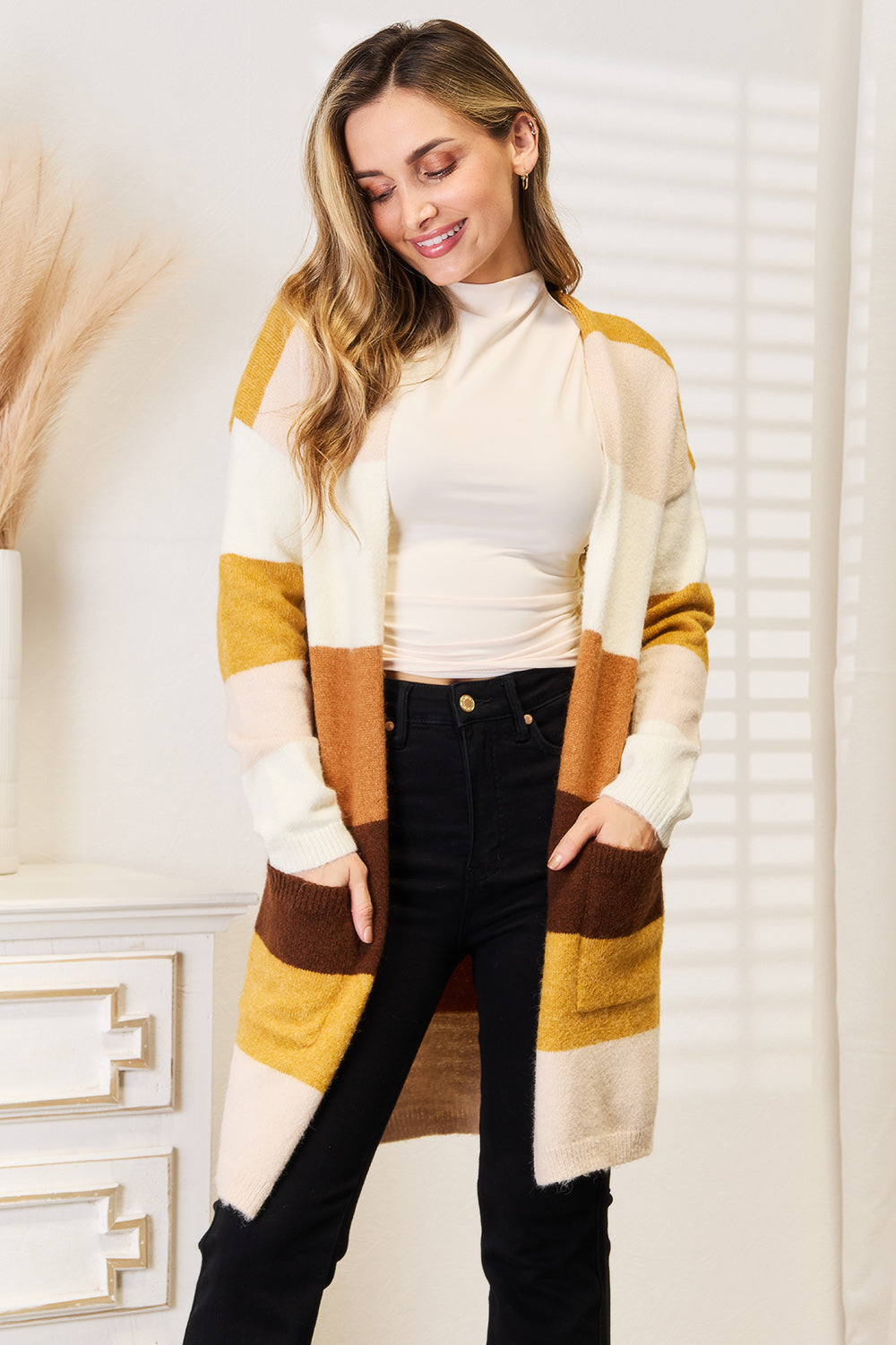 Woven Right color block cardigan in cream, tan, brown and mustard worn over a cream top and black pants