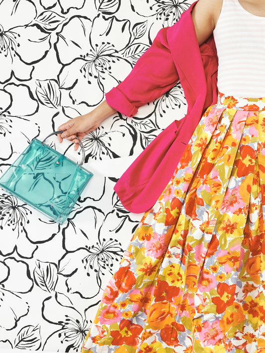 a woman in a floral dress and pink cardigan
