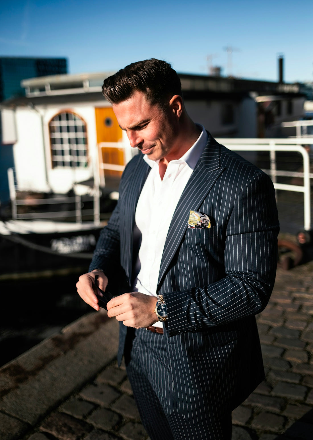 a man in a pinstripe suit looking at his cell phone