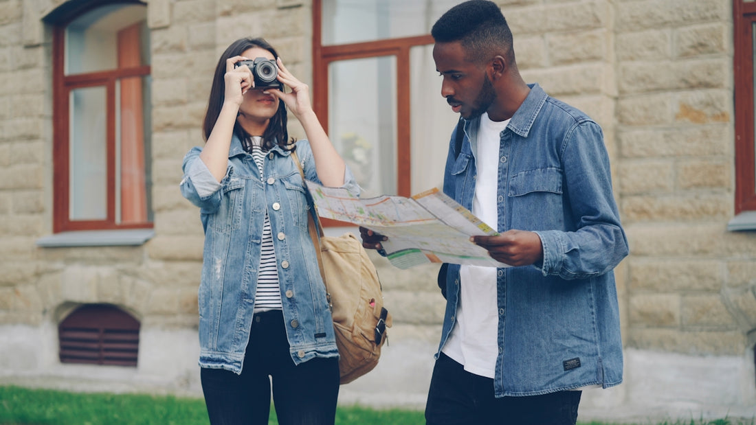 Woman takes a photo while the man looks at a map.