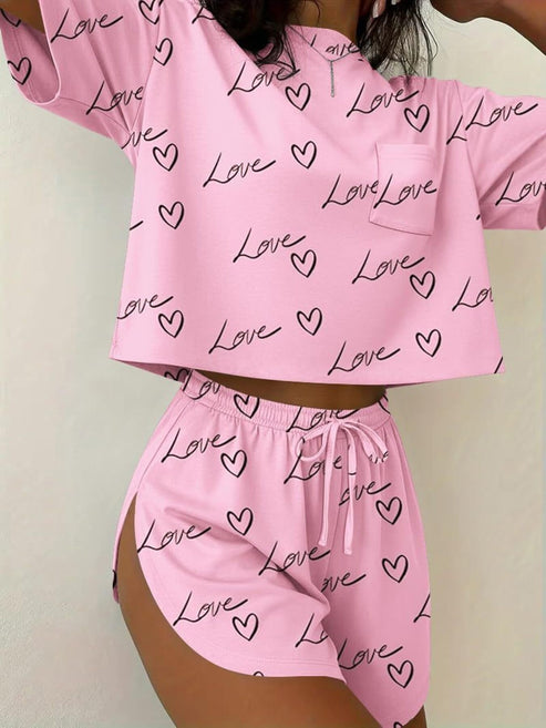 Pink lounge wear set with love and heart print, cropped top and drawstring shorts.